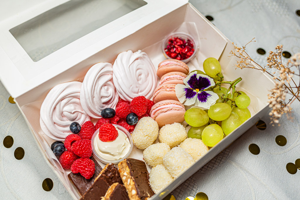 Boîte de snacking sucrée composée de fruits et mignardises